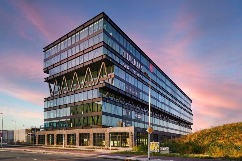 Modern kantoorgebouw The Joan aan de Joan Muyskenweg in Amsterdam bij zonsondergang.